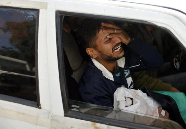 The father of Palestinian baby girl Hanen Tafish, who according to hospital officials was killed in an Israeli air strike, carries her body as he sits in a car during her funeral in the northern Gaza Strip November 16, 2012.